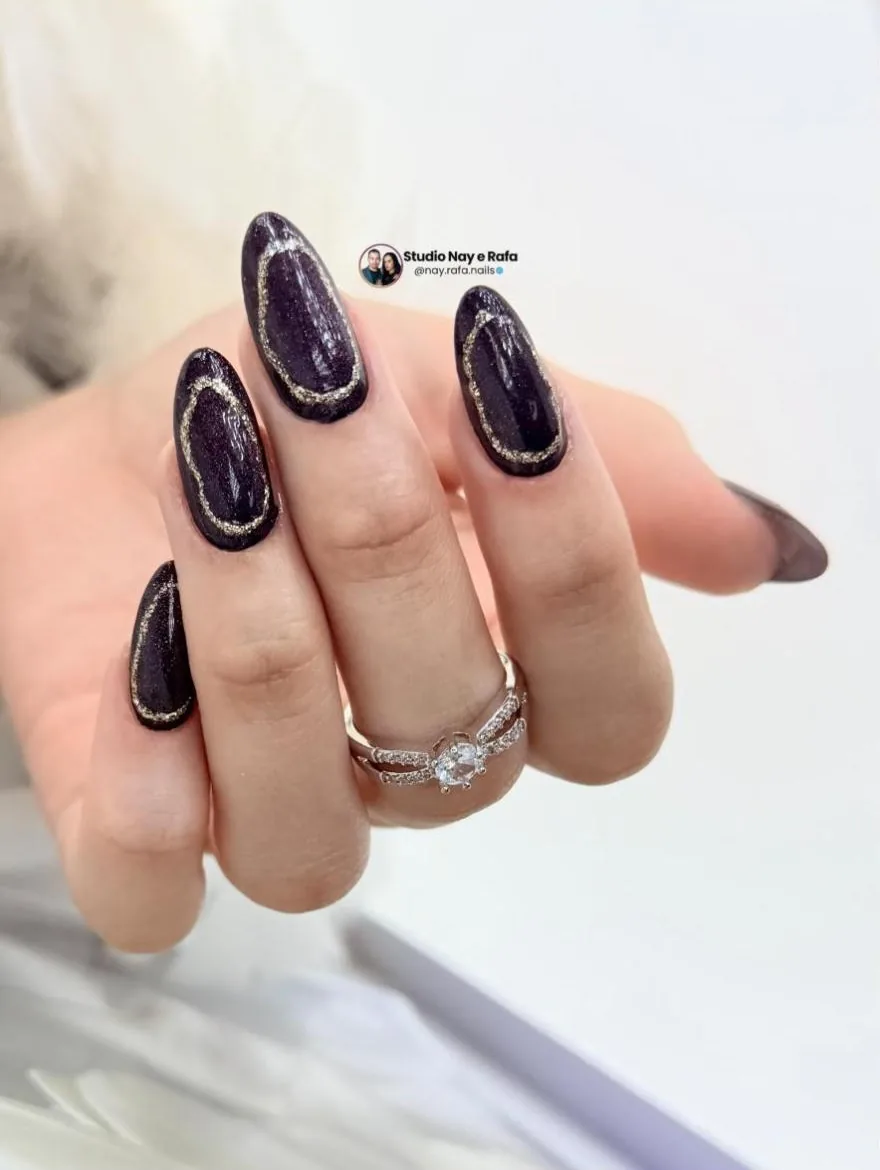 Unhas amendoadas escuras com contorno dourado