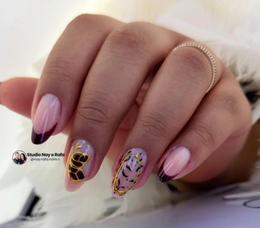 Unhas com francesinha escura e desenhos em dourado